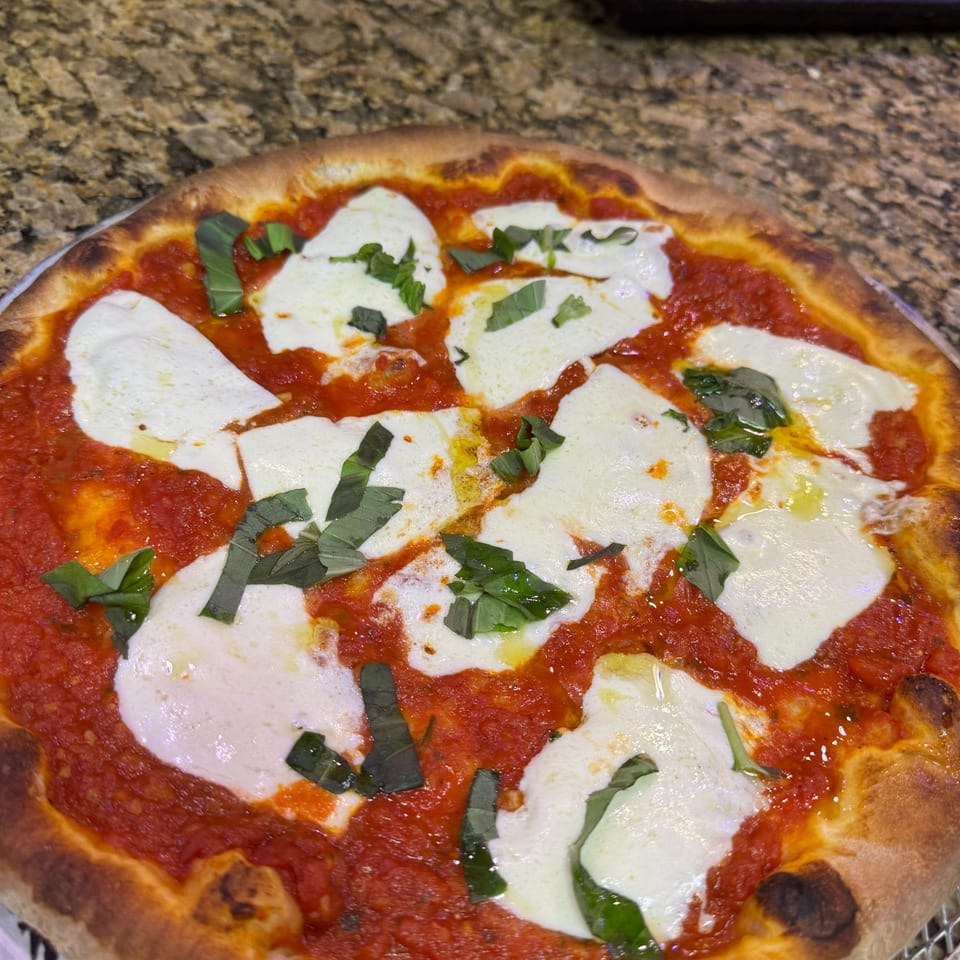 Rosario's Trattoria & Pizzeria's Margherita pizza with fresh mozzarella, vibrant tomato sauce, and basil.