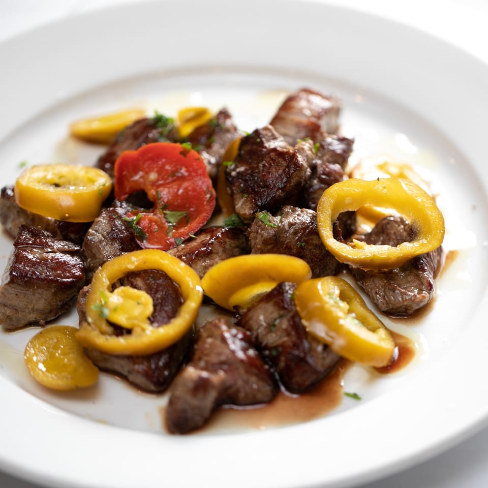 Rosario's Trattoria & Pizzeria's steak bites with yellow and red peppers, drizzled with sauce.