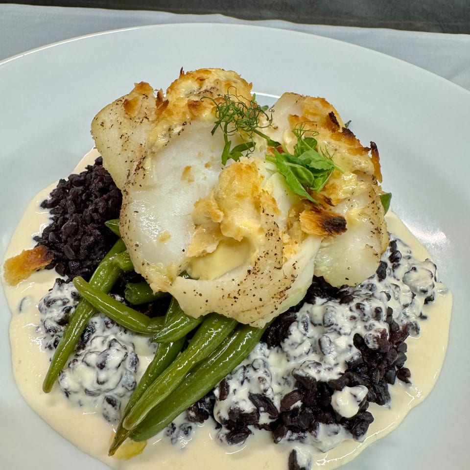 Rosario's Trattoria & Pizzeria's baked fish with green beans and black risotto in a creamy sauce.