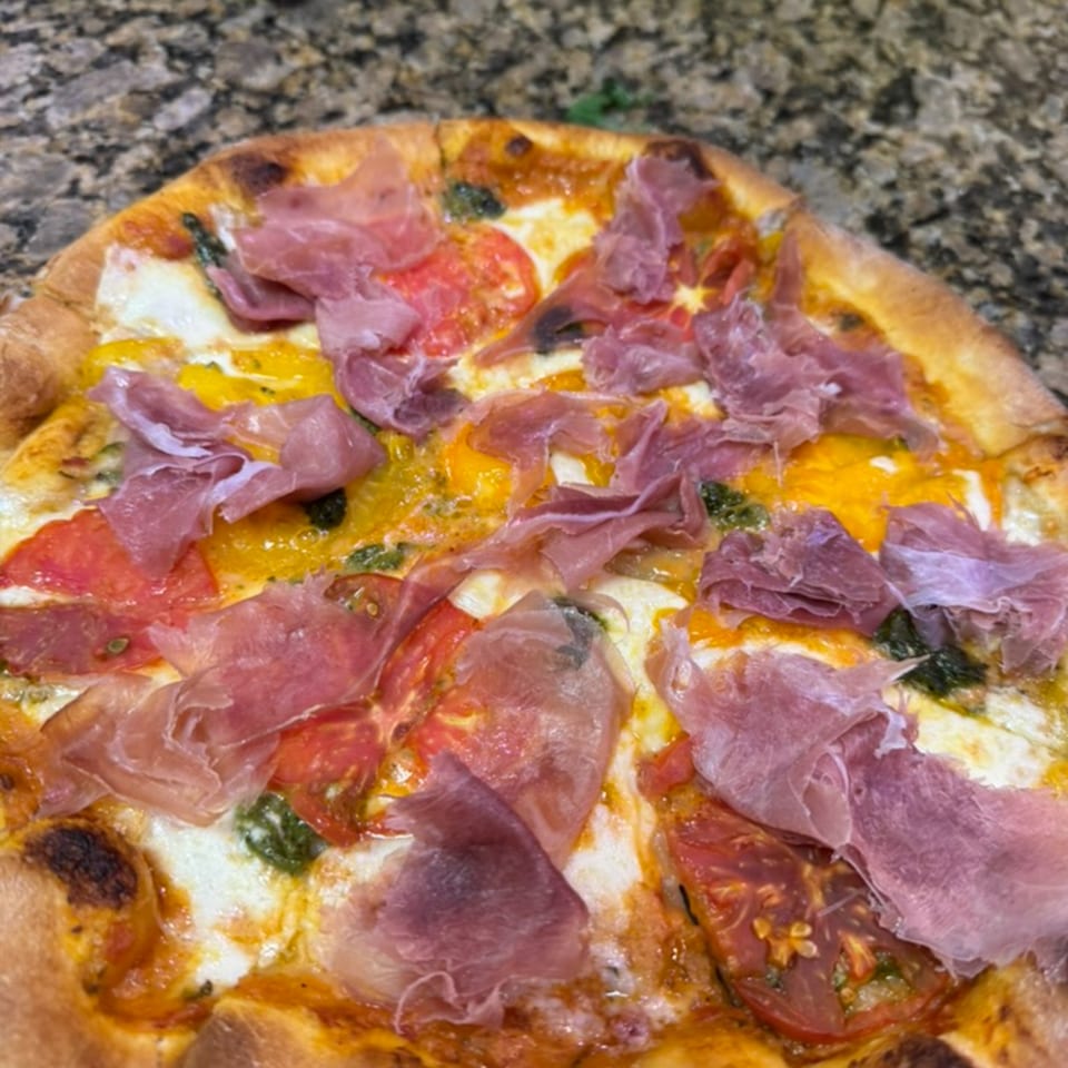 Rosario's Trattoria & Pizzeria's Italian pizza, topped with prosciutto, tomatoes, and cheese.