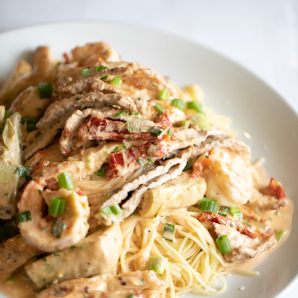 Rosario's Trattoria & Pizzeria's creamy pasta dish with chicken, shrimp, sun-dried tomatoes, and scallions.