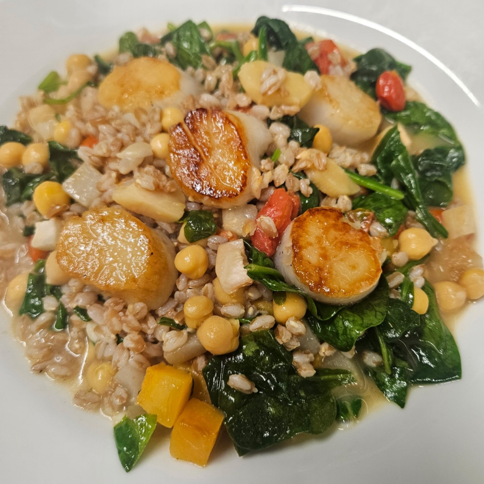 Bowl of farro with seared scallops, chickpeas, spinach, tomatoes, onions, and roasted squash.