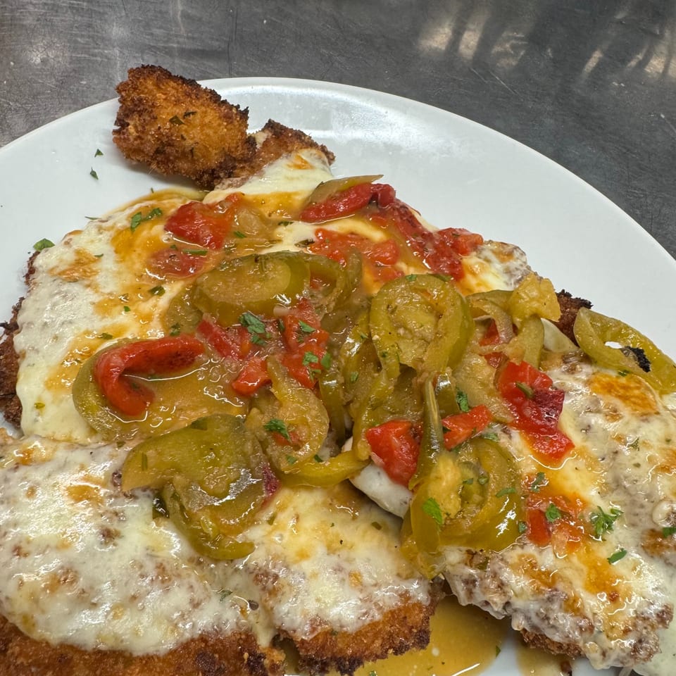 Rosario's Trattoria & Pizzeria's chicken parmesan topped with melted cheese, red and green peppers.