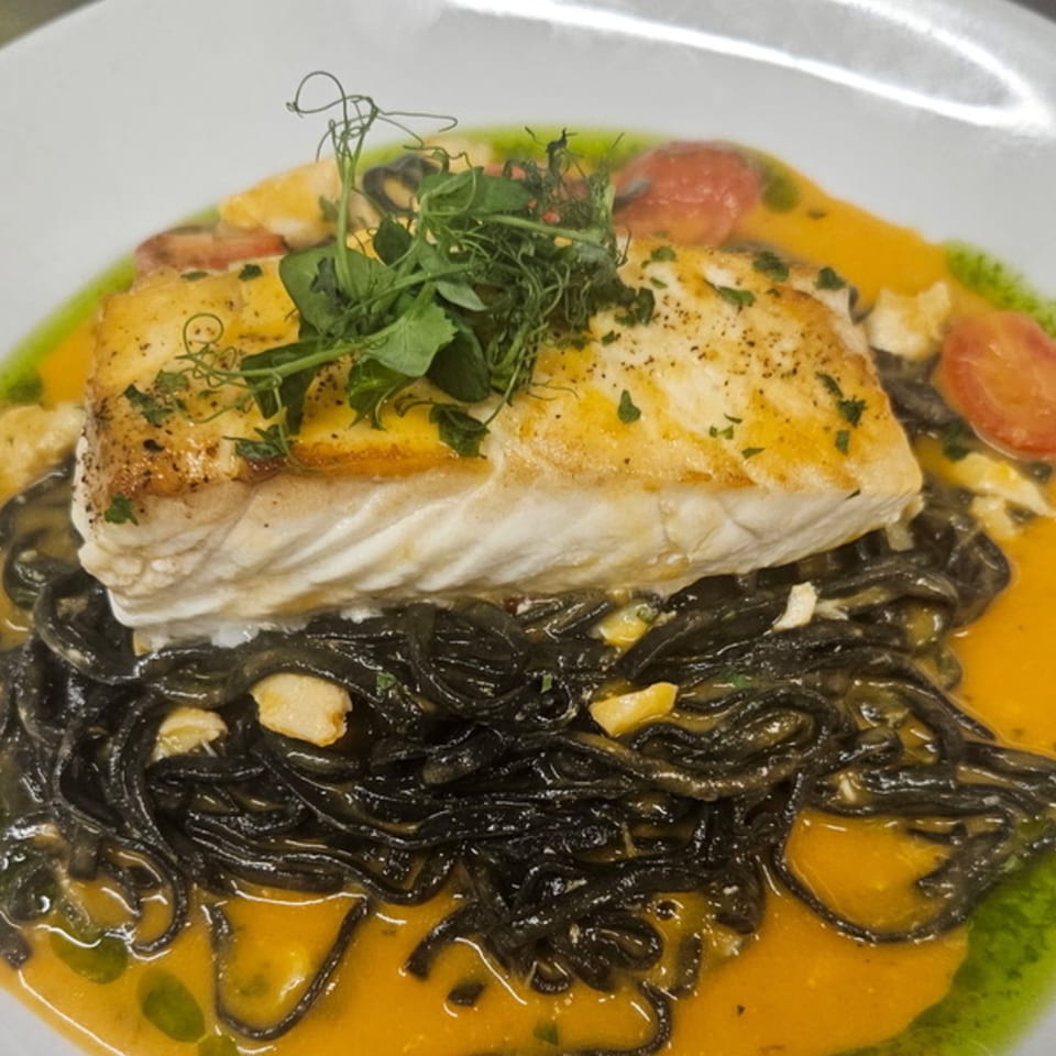Rosario's Trattoria & Pizzeria's pan-seared fish over black squid ink pasta in a creamy orange sauce.